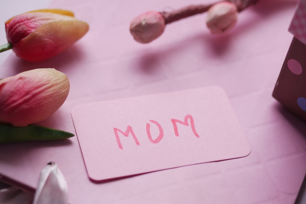 Pink floral Mother's Day card with tulips and gift box, perfect for celebrating mom.
